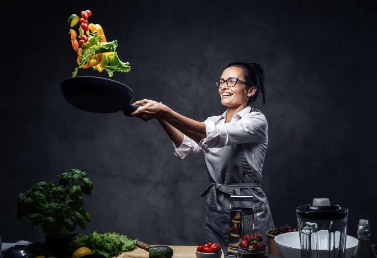 Happy middle aged female chef tossing chopped vege 2025 01 26 22 49 30 utc